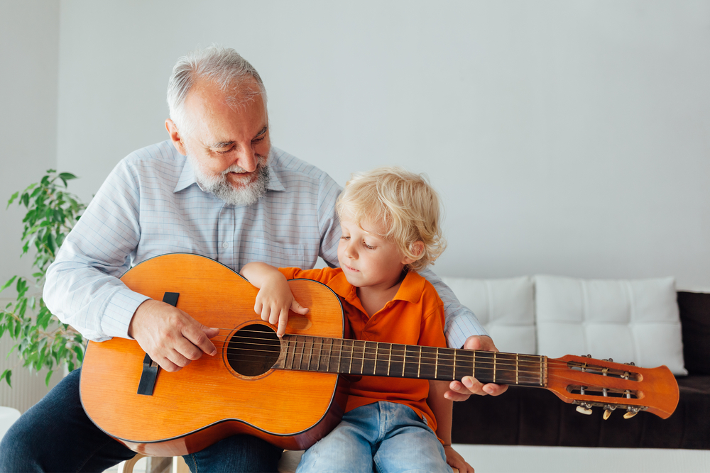 grandson-and-grandfather-playing-guitar
